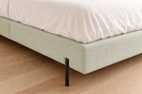 PANDORA olive green upholstered bed base with white bedding and slim black legs. PANDORA olive green upholstered bed base with white bedding and slim black legs.
