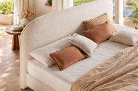 ZOLE curved upholstered headboard with rounded silhouette in textured fabric.