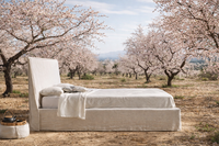 Cama de lino fabricada con tejidos naturales situada en un campo de almendros en flor, destacando un diseño orgánico y un estilo Cama de lino fabricada con tejidos naturales situada en un campo de almendros en flor, destacando un diseño orgánico y un estilo